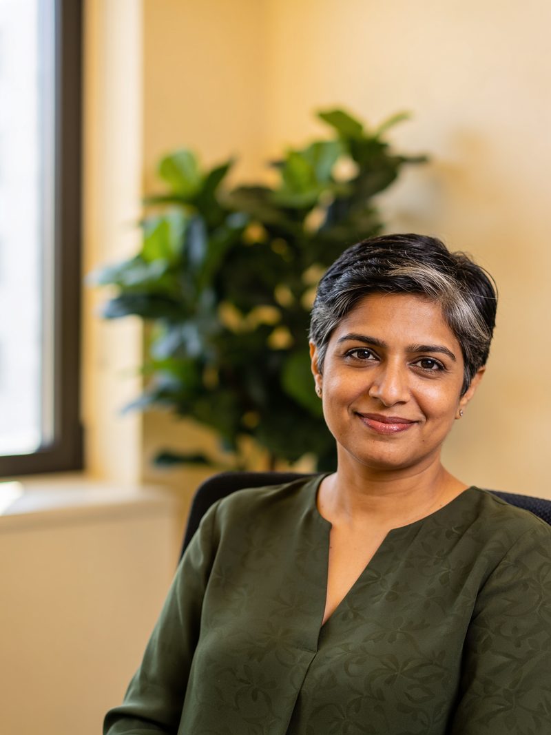 Portrait of Meera Raghavan, a partner, in a bright office